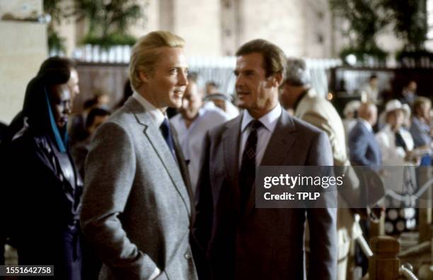 American actor Christopher Walken, is Max Zorin and English actor Roger Moore , is James Bond, stand on set during the filming of the 1985 James Bond...