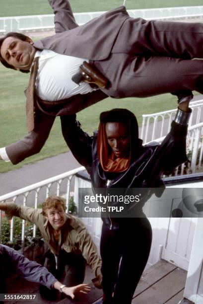 Jamaican-American model Grace Jones, is May Day, dressed in costume, holds New Zealand actor Bogdan Kominowski at Royal Ascot Racecourse during the...