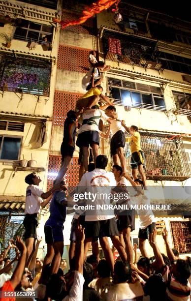 Indian devotees of Hindu God Lord Krishna prepare to form a seven-tier human pyramid as they practise for "dahi-handi"- contest in Mumbai, late 25...