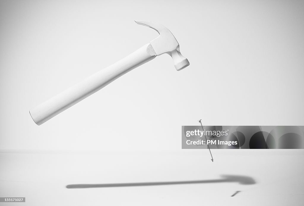 White hammer and nail levitating