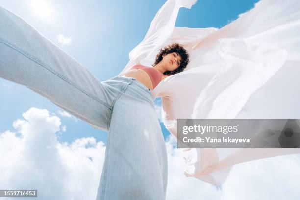 a beautiful asian woman with curly hair is dancing, waving a white cloth, wide angle shot from below - showus - fotografias e filmes do acervo