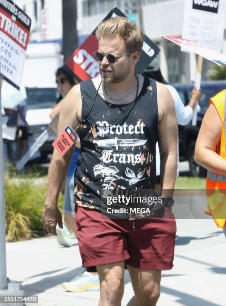 Adam Conover is seen picketing with SAG-AFTRA and WGA members outside of Netlifx studios on July 24, 2023 in Los Angeles, California.