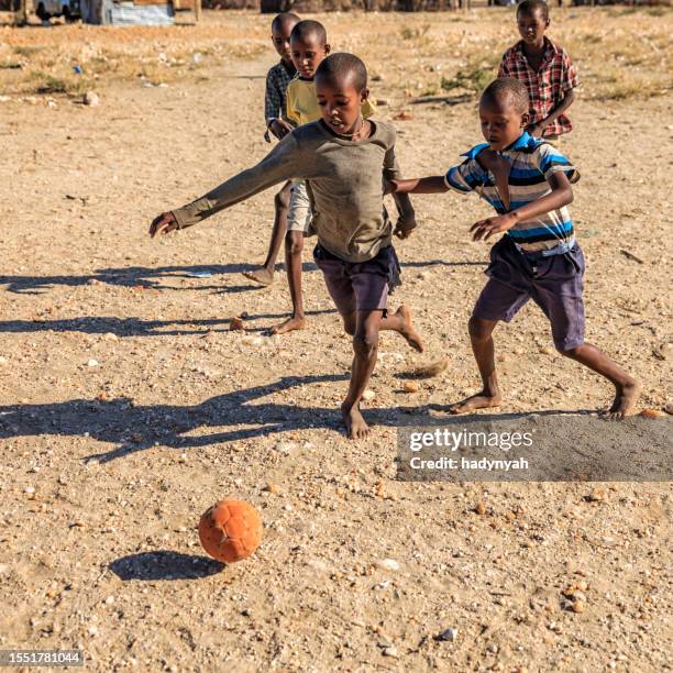 barefoot african children playing football in the village, east africa - poor kids playing soccer stock pictures, royalty-free photos & images