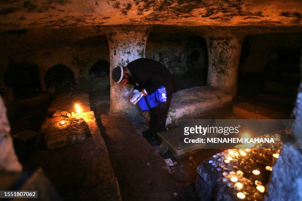Jewish woman prays 20 July 2007 in a cave that contains tombs of holy Jewish rabbis at the ancient cemetery of the northern Israeli city of Safed a...