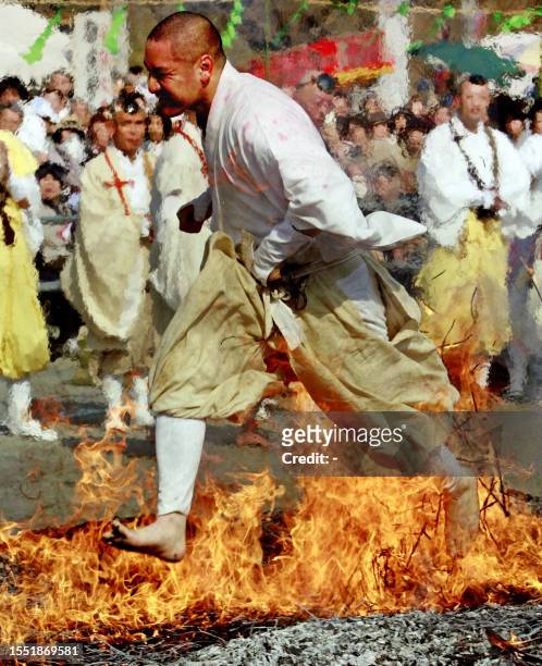 Buddhist monk walks barefoot over fire in a ritual ceremony which heralds the coming of spring at the Chichibu fire festival in Nagatoro town,...