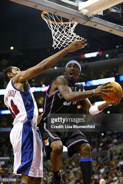 Ricky Davis of the Cleveland Cavaliers gets under the basket against Michael Olowokandi of the Los Angeles Clippers in the season opener on October...