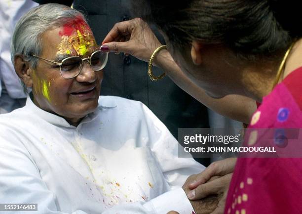 Indian Prime Minister Atal Behari Vajpayee is daubed with festive "Holi" colours by an unidentified reveller during Holi celebrations at his...