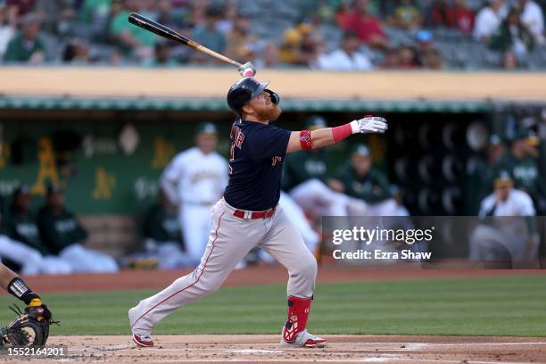 Justin Turner of the Boston Red Sox hits a sacrifice fly that scored a run against the Oakland Athletics in the first inning at RingCentral Coliseum...