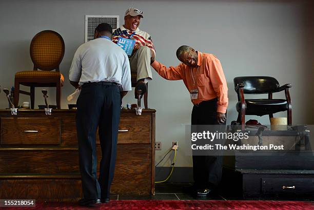 William Robinson shines the shoes of DNC convention goer George Davis who jokes with employee Isaiah Jones at the Charlotte Convention Center held in...