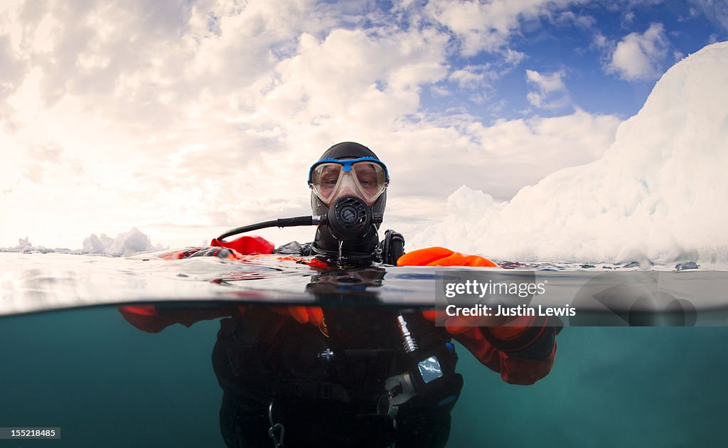 Scuba diver next to an iceberg - split shot