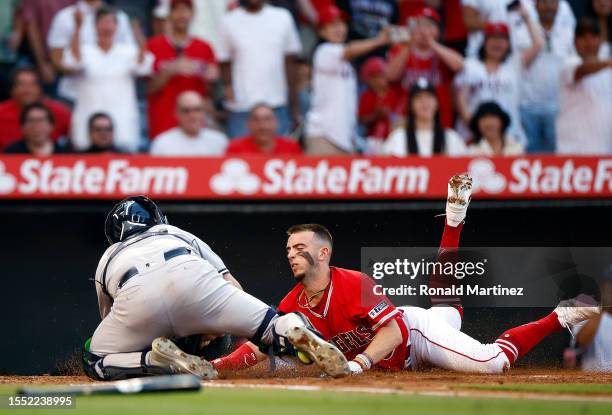 Jose Trevino of the New York Yankees makes the out at home plate against Zach Neto of the Los Angeles Angels in the third inning at Angel Stadium of...