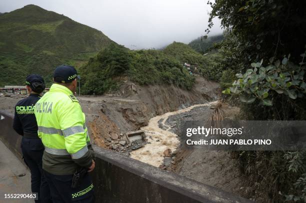 Policer officers look at damage caused by a landslide last week along a river in the municipality of Quetame, Cundinamarca Department, Colombia, on...