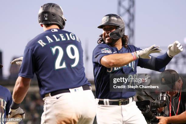 Eugenio Suarez of the Seattle Mariners celebrates his two run home run with Cal Raleigh against the Minnesota Twins during the seventh inning at...