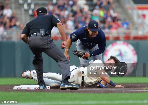 Eugenio Suarez of the Seattle Mariners makes the tag on Edouard Julien of the Minnesota Twins in the sixth inning at Target Field on July 24, 2023 in...