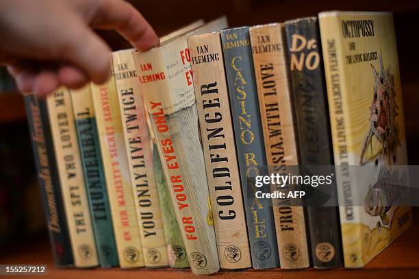 Book dealer Jon Gilbert poses with a full collection of first edition copies of Ian Fleming's James Bond books during the Chelsea Antiquarian Book...