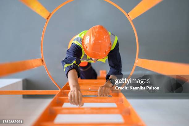 high angle look down view over young asian technician worker climbing ladder for inspect or maintenance machine in high voltage electric transformer sub station. industrial business occupation worker concept. - workplace danger stock pictures, royalty-free photos & images