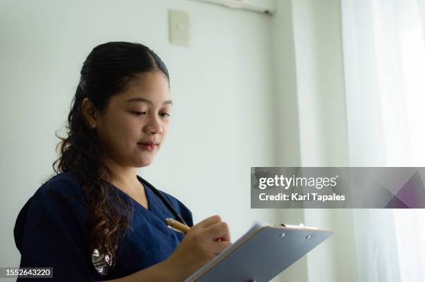 portrait of a young southeast asian female doctor in the clinic - philippines stockfoto's en -beelden