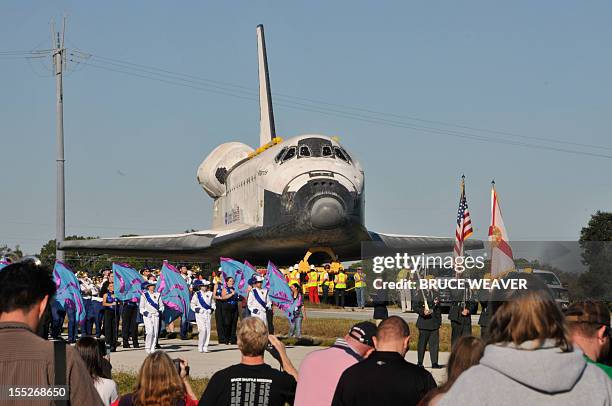 Workers and visitors watch the US Space Shuttle Atlantis moves on November 2, 2012 to the Visitors Center at Kennedy Space Center in Cape Canaveral,...