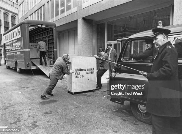 Crates of criminal records are moved into the new premises of New Scotland Yard, the headquarters of the Metropolitan Police Service, on Victoria...