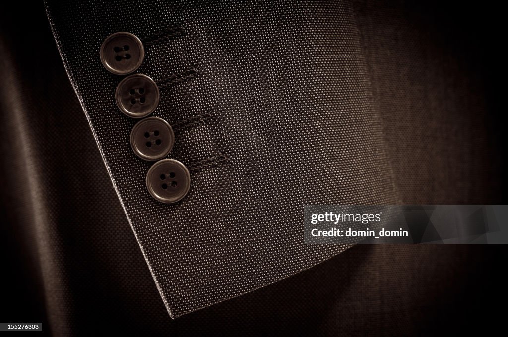 Close-up of suit's sleeve and buttons in brown colour