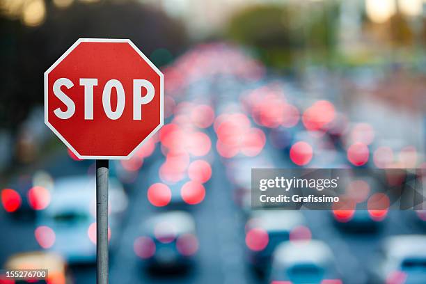 stop sign with traffic and cars at rush hour - caution sign traffic stockfoto's en -beelden