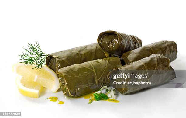 a pile of dolmades with lemon on a white background - grape leaf stock pictures, royalty-free photos & images