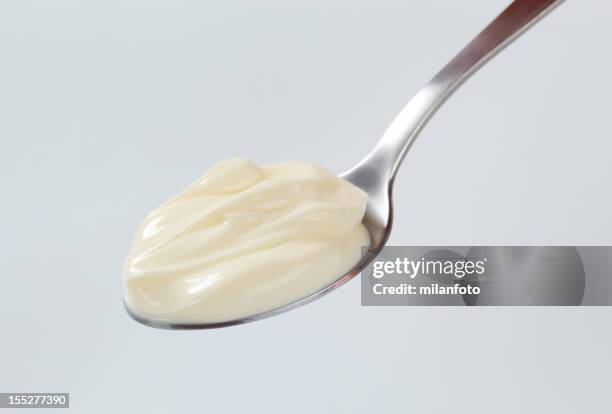 a teaspoon with a dollop of thick cream on it - grädde bildbanksfoton och bilder