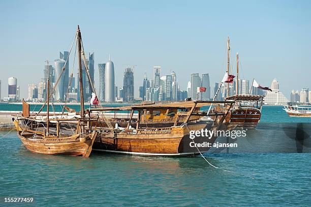 dhows in the harbor of doha, qatar on clear day - dhow stock pictures, royalty-free photos & images