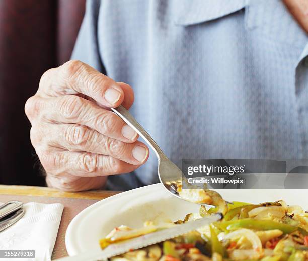 senior man fingers holding breakfast fork close-up - eating stock pictures, royalty-free photos & images