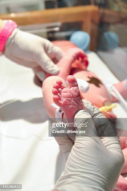 nurse examining newborn baby's foot. - human foot stock pictures, royalty-free photos & images