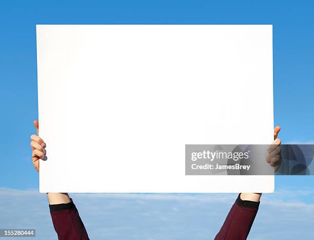 manos sosteniendo en blanco blanco signo en sky - cartel fotografías e imágenes de stock