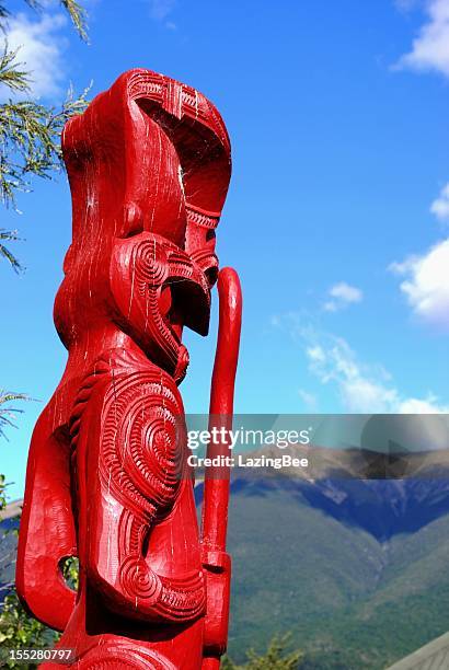 maori totem (pou) looking out to distant mountains - maori carving stock pictures, royalty-free photos & images