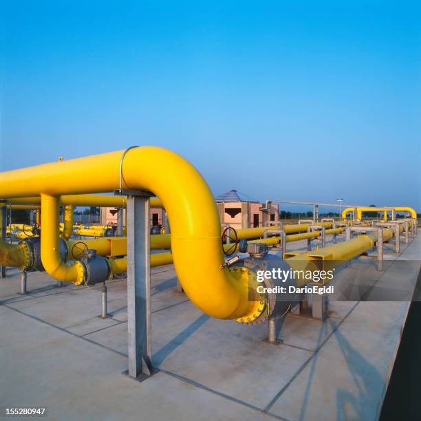 gelbe rohre in ein gasversorger station, blauer himmel hintergrund - gas cylinder stock-fotos und bilder