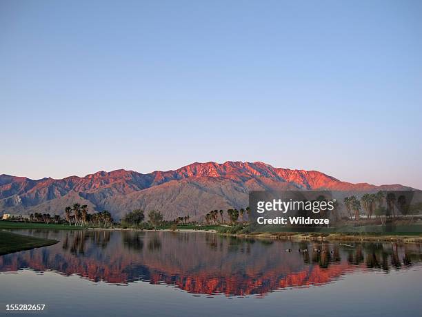 golf course at dawn with sunrise kissed mountains - palm springs california stockfoto's en -beelden