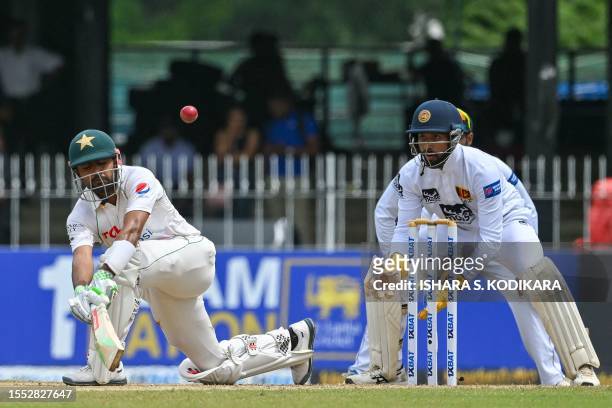 Pakistan's Babar Azam plays a shot as Sri Lanka's wicketkeeper Sadeera Samarawickrama watches during the second day of the second and final cricket...