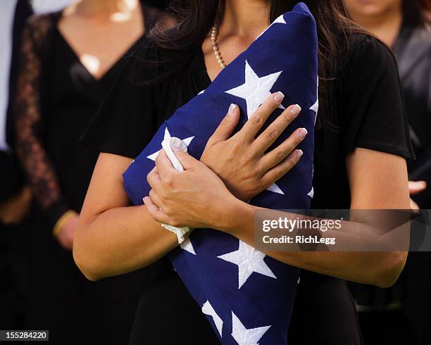 mujer sosteniendo una bandera de funeral - viuda fotografías e imágenes de stock