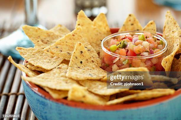 a close-up of a bowl of chips and salsa - tortilla chip stock pictures, royalty-free photos & images