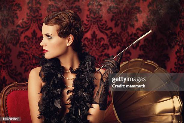 retro woman listening to music and smoking cigarette - women in the 1920's stockfoto's en -beelden