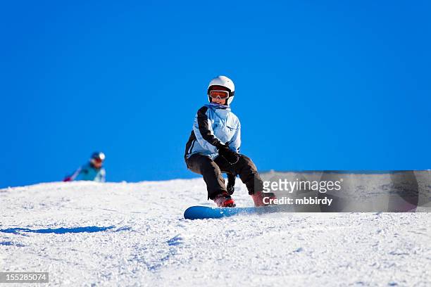 teenage girl snowboarding on sunny winter day - kids skiing stock pictures, royalty-free photos & images