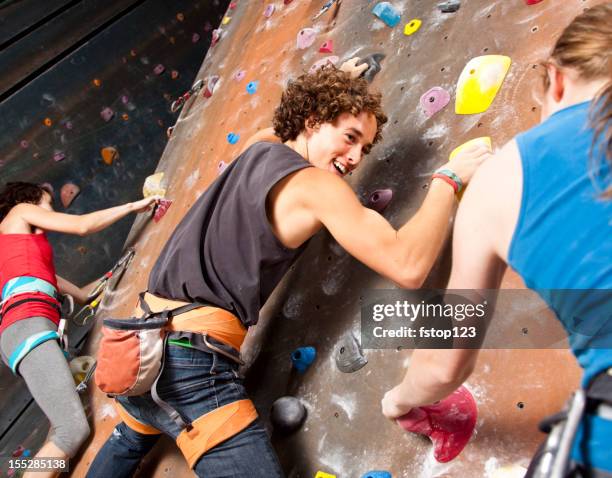 three happy teenagers having fun at rock climbing wall - climbing wall stock pictures, royalty-free photos & images