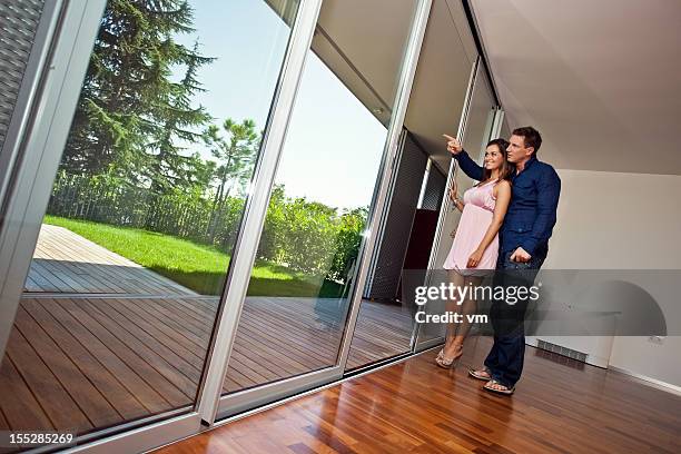 jeune couple dans un nouveau téléviseur à écran plat - porte d'accès à la terrasse photos et images de collection