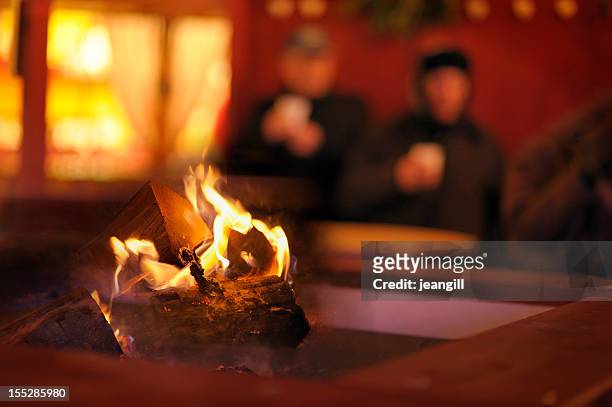 homeless couple by log fire outdoors - apres ski stock pictures, royalty-free photos & images