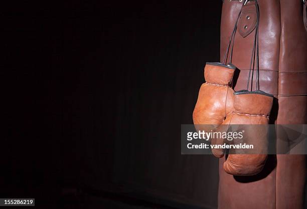 old fashioned boxing gloves and punching bag - punching bag stock pictures, royalty-free photos & images