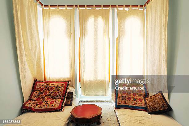 farbenfrohe, helle wohnzimmer mit weißen vorhängen und matratze, indien - udaipur palace stock-fotos und bilder
