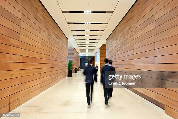 business people moving along the corridor - wood ceiling stock pictures, royalty-free photos & images