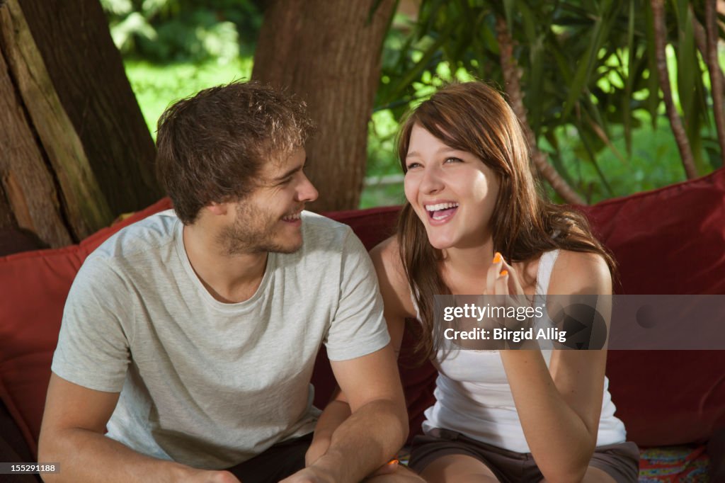 Young couple sitting on sofa outside,having fun