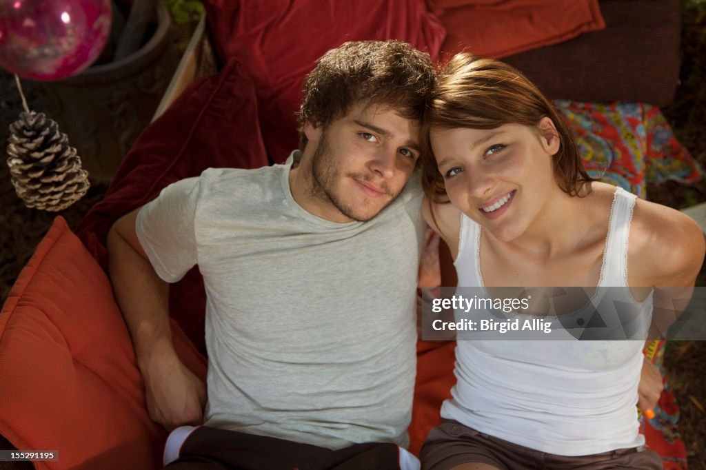 Young couple relaxing on sofa outside