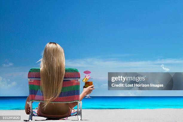 woman relaxing in lawn chair on beach - cocktails beach stock pictures, royalty-free photos & images