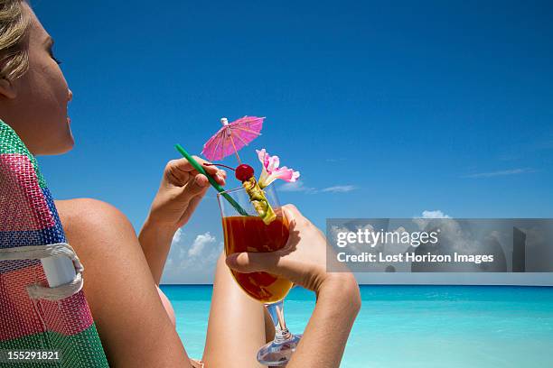 woman with tropical drink on beach - paper umbrella stock pictures, royalty-free photos & images