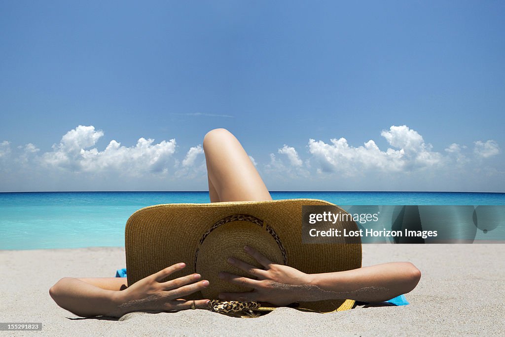 Woman laying on towel on beach